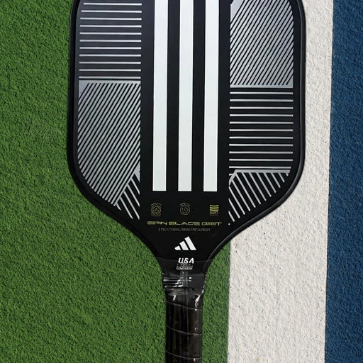 padelpickleball.store adidas Match pickleball paddle with black and white three-stripe design on a court surface